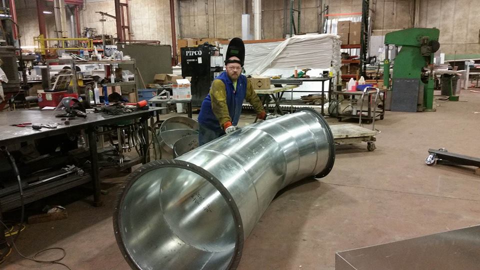 Picture of Local 1 member with his completed fabrication of round industrial ductwork